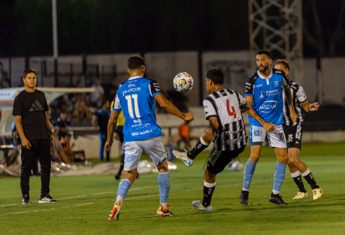 Two players contesting the ball in mid-air during a night match