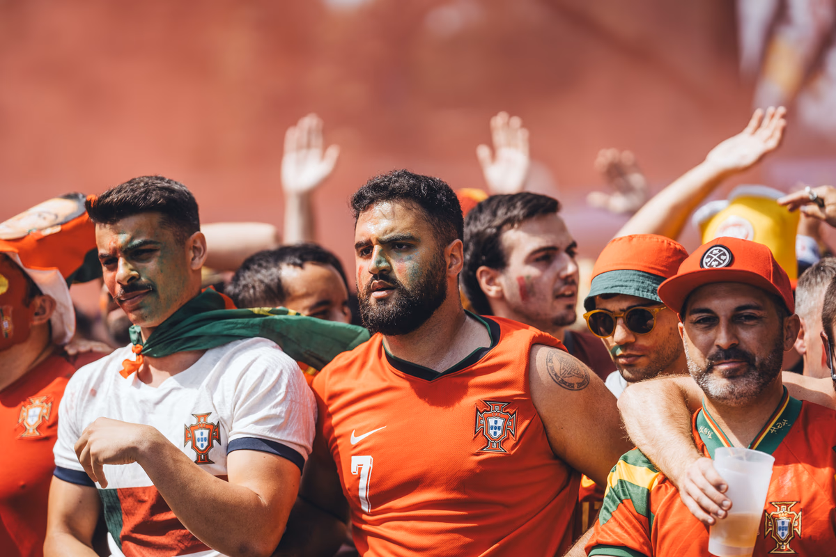 A group of fans in national colours cheering outdoors